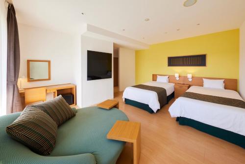 a hotel room with two beds and a couch at Hotel Rotterdam Huis Ten Bosch in Sasebo