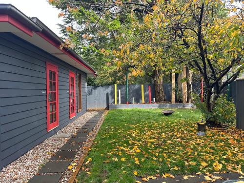 a house with a red door and a yard with leaves at Cosy and Pet Friendly Blackheath Studio 2 in Blackheath