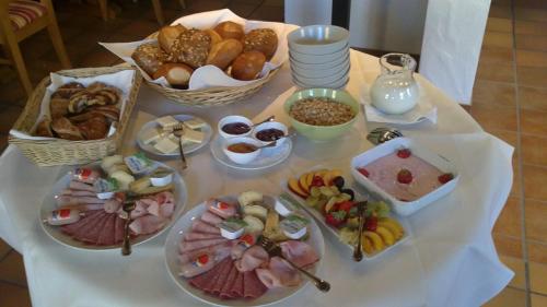a table with plates of food and baskets of pastries at Ellenbergs Restaurant & Hotel in Heßheim