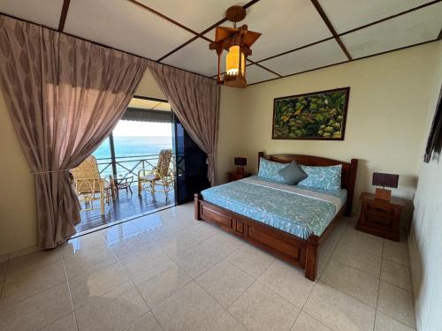 a bedroom with a bed and a balcony at Minang Cove Resort in Tioman Island