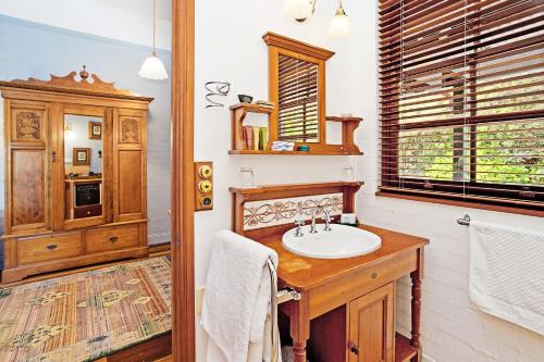 a bathroom with a sink and a wooden cabinet at Montville Boutique BnB in Montville