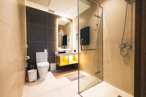 a bathroom with a toilet and a glass shower at May Seven Hotel and Suites in Ulaanbaatar