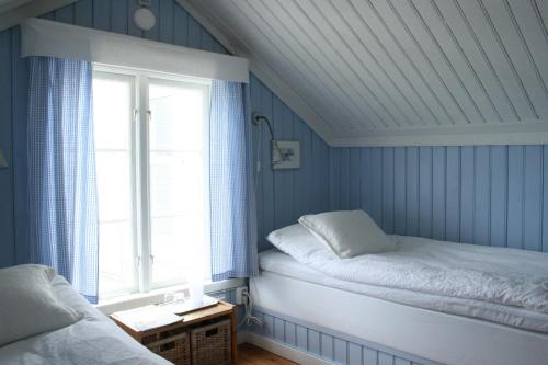 a bedroom with a bed and a window with blue walls at Uddens Bed & Breakfast in Öregrund