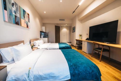 a hotel room with a large bed and a flat screen tv at May Seven Hotel and Suites in Ulaanbaatar