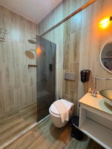 a bathroom with a shower and a toilet and a sink at ÇAKIR's HOME OTEL in Çeşme