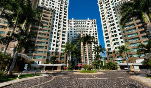 a city street with palm trees and tall buildings at Grand Venetian Comfort in Puerto Vallarta