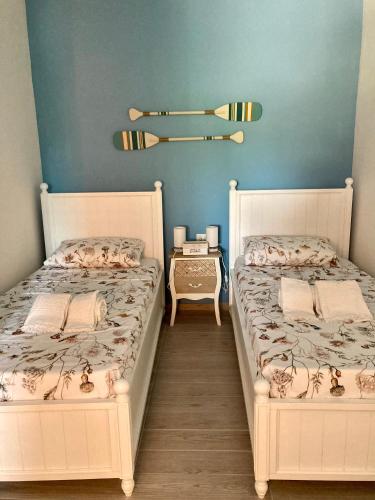 two twin beds in a room with blue walls at Relax e tranquillità a Cala Pisana in Lampedusa