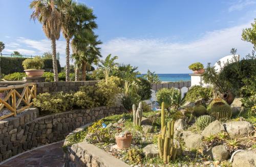 a garden with cacti and the ocean in the background at Hotel Terme Tritone Resort & Spa in Ischia