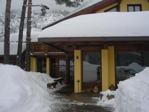 a building covered in snow with a person standing outside at Hotel Cà Fiore in Bardonecchia