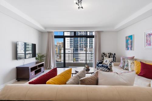 a living room with a couch and a large window at Built on Hope De Waterkant in Cape Town
