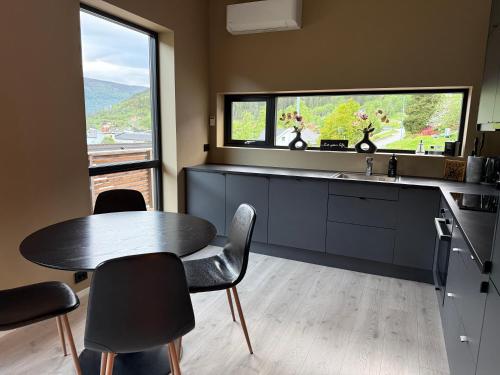 a kitchen with a table and chairs and a window at Aurora Apartments - Mountain View in Stryn