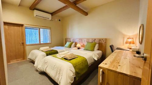 a bedroom with two beds and a window at Loving Garden Stayラビングガーデンステイ in Mima
