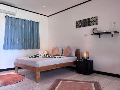 ein Schlafzimmer mit einem Bett und einem blauen Vorhang in der Unterkunft Cliffside Resort in Panglao