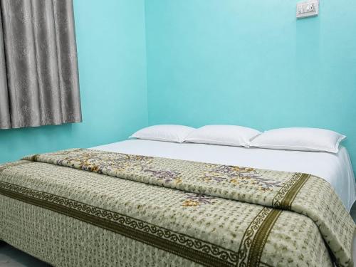 a bedroom with a bed with a blue wall at santosh lodge in Muzaffarpur