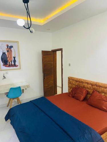 ein Schlafzimmer mit einem Bett mit blauer Bettdecke in der Unterkunft Double Homes in Agege