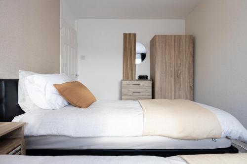 a bedroom with a large bed with white sheets at Peaceful hideaway with homely comforts in Timperley