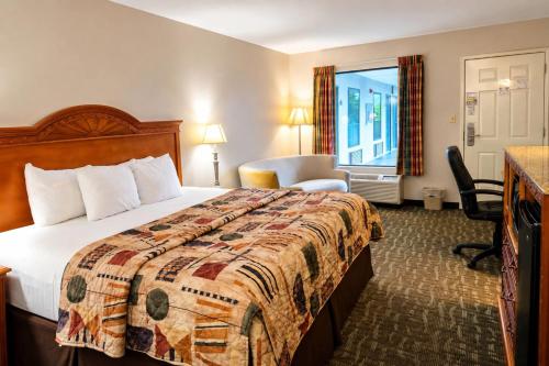 a hotel room with a bed and a window at Days Inn by Wyndham Apple Valley Pigeon Forge/Sevierville in Pigeon Forge