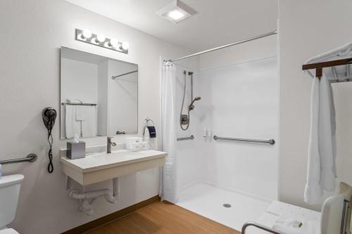 a white bathroom with a sink and a shower at Super 8 by Wyndham Montpelier - Bear Lake in Montpelier