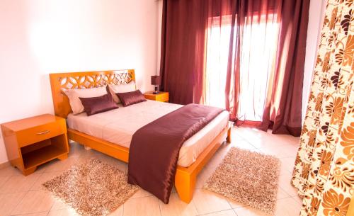 a bedroom with a bed and a large window at Mahdia Place Apartments in Mahdia
