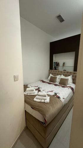 a bedroom with a large bed with towels on it at TIM Apartment Sarajevo with private parking in Sarajevo