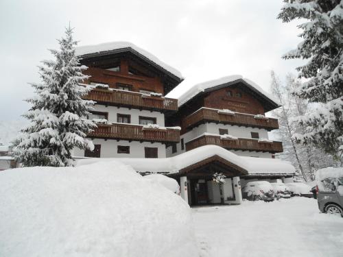 un grande edificio ricoperto di neve con un'auto parcheggiata di fronte di Hotel Principe a Cortina dʼAmpezzo