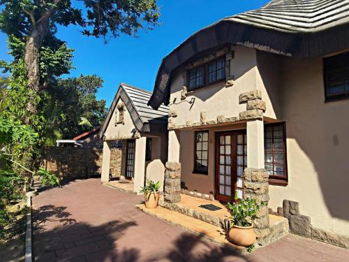 a large white house with a tile roof at Forest Lodge - Richards Bay in Richards Bay