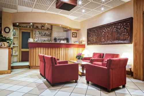 a living room filled with furniture and a red wall at Hotel Roma in Aosta