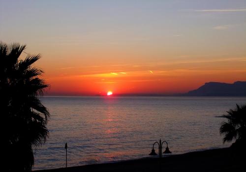a sunset over the ocean with the sun setting at Hotel Kaly in Ventimiglia