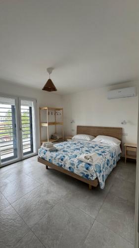 a bedroom with a bed with a blue comforter at Sea and Airport View in Fiumicino