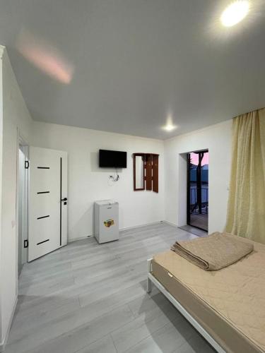 a bedroom with a bed and a tv on the wall at База отдыха Golden rest in Borovoye
