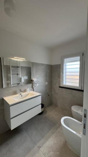 a bathroom with a sink and a tub and a toilet at Sea and Airport View in Fiumicino