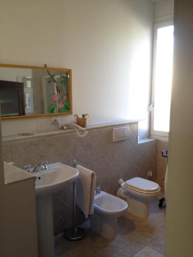 a bathroom with a sink and a toilet and a mirror at B&B Le Tortore in Melara