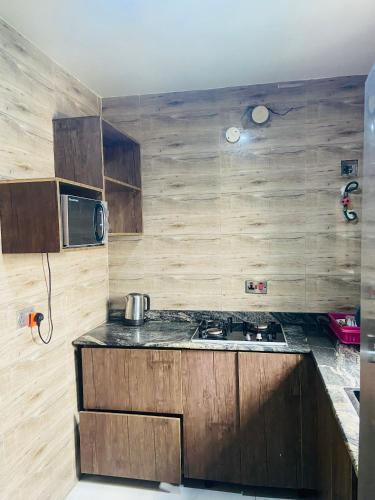 a kitchen with wooden cabinets and a stove top oven at Double Homes in Agbelekale
