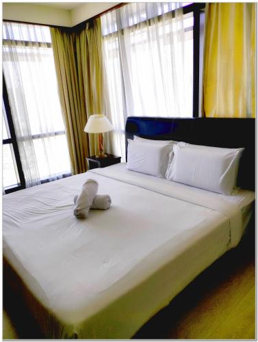 a bed with a stuffed animal laying on it at Concord service suite time square in Kuala Lumpur