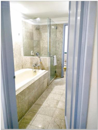 a bathroom with a bath tub and a shower at Concord service suite time square in Kuala Lumpur