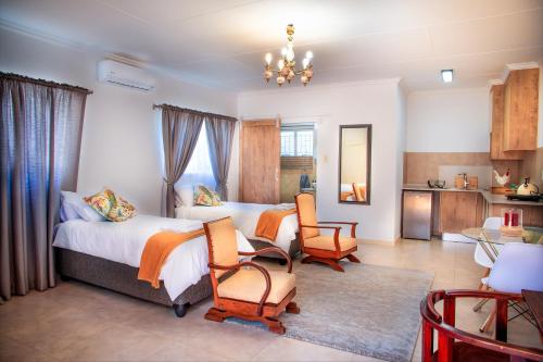 a bedroom with a bed and two chairs and a table at Jac-Marie guests accommodation in Tzaneen