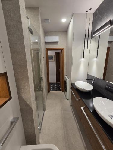 a bathroom with two sinks and a walk in shower at Apartments Romana in Postira