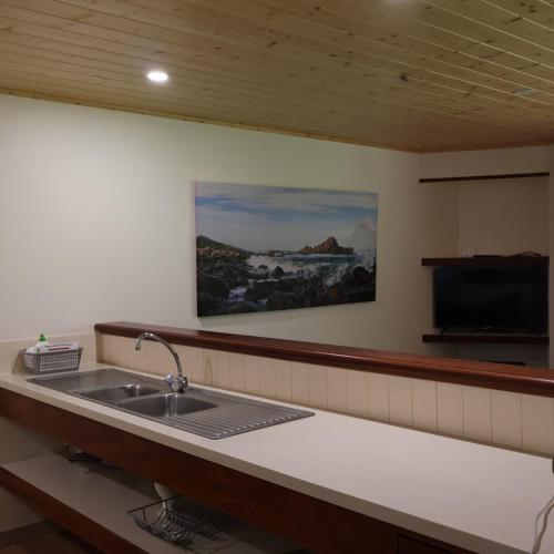 a kitchen with a sink and a tv on the wall at Siesta Park Holiday Resort ABSOLUTE BEACHFRONT RESORT in Busselton