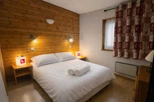 a bedroom with a white bed with two towels on it at Chalet 8 pers Vars SteMarie Calme in Vars