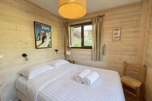 a bedroom with a bed with two towels on it at Chalet 8 pers Vars SteMarie Calme in Vars