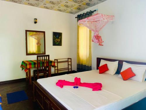 a bedroom with a bed with a pink bow on it at Die Elefanten Udawalawe in Udawalawe