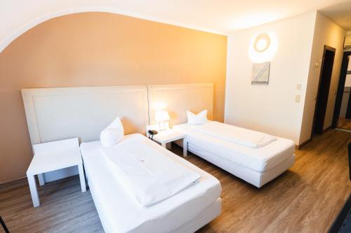 ein Hotelzimmer mit zwei Betten und einem Tisch in der Unterkunft Skycity Hotel Atrigon in Klagenfurt am Wörthersee