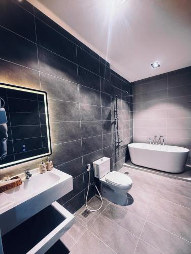 a bathroom with a tub and a toilet and a sink at Hotel Trung Đông 2 in Ấp Bình Thương