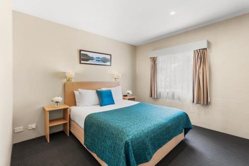 a hotel room with a bed and a window at Bay View Villas in Hobart