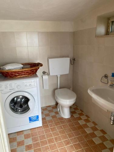 a bathroom with a washing machine and a toilet at Trullo Raimondo in Martina Franca