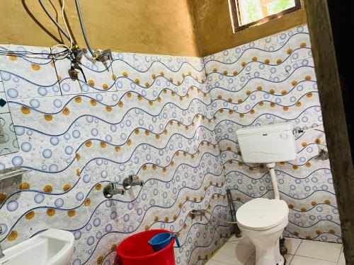a bathroom with a toilet and a sink at Pond & Stone Homestay in Banjār