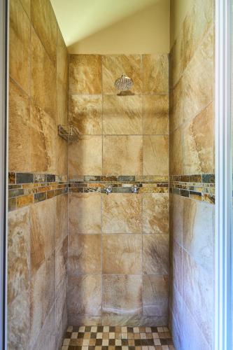 a bathroom with a large shower with tiled walls at Sable Ranch Bush Lodge in Brits