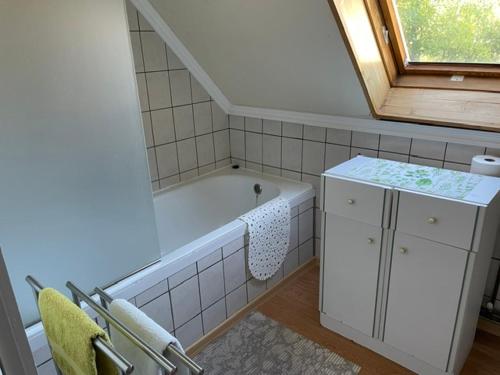 a bathroom with a tub and a sink and a window at Kamilla Apartman in Fonyód
