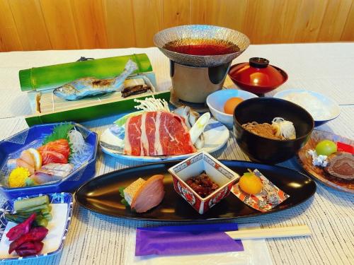 a table with a plate of food on a table at Hotel & Onsen 2307 Shigakogen in Yamanouchi