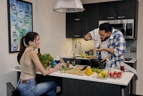 a man and woman preparing food in a kitchen at Hyatt House Fishkill-Poughkeepsie in Fishkill